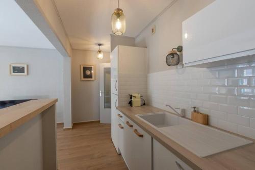 - une cuisine avec un évier et un comptoir dans l'établissement CABANA & La Calade - Centre-Ville, à Villefranche-sur-Saône