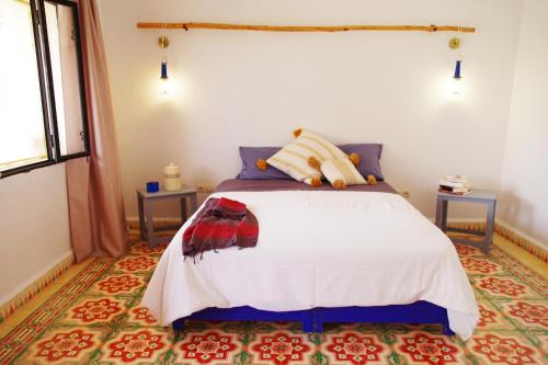 een slaapkamer met een bed en 2 tafels bij Artgana Lodge in Essaouira