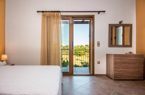 sypialnia z łóżkiem i przesuwnymi szklanymi drzwiami w obiekcie VILLA IRIDA w mieście Kefalonia