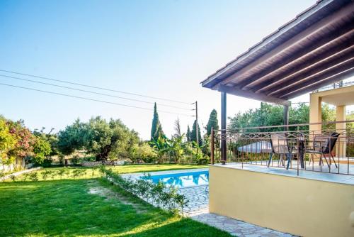 a patio with a table and chairs next to a yard at VILLA IRIDA in Kefallonia