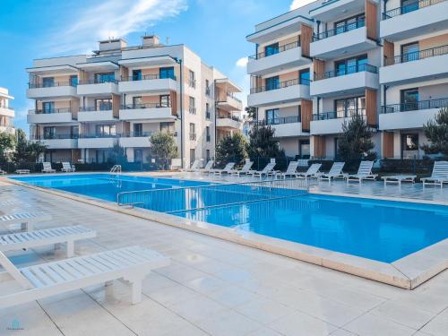 a swimming pool in front of a apartment building at Pod Brzozami Apartamenty Rezydencja Ustronie Morskie in Ustronie Morskie