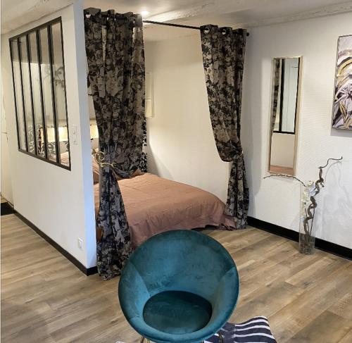 Cette chambre comprend une chaise bleue et un lit. dans l'établissement Studio de charme au coeur de Vannes - 3 pers, à Vannes