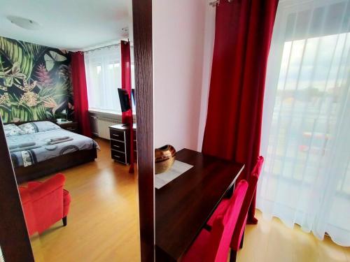 a room with a desk and a bedroom with a bed at Apartamenty Częstochowa in Częstochowa