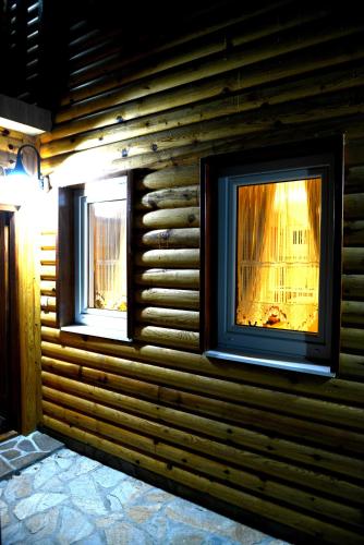 two windows on a wall of a log cabin at Snežna Kuća Apartments in Kopaonik