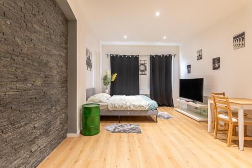 a bedroom with a brick wall and a table and a bed at Studio HyperCentre Strasbourg in Strasbourg