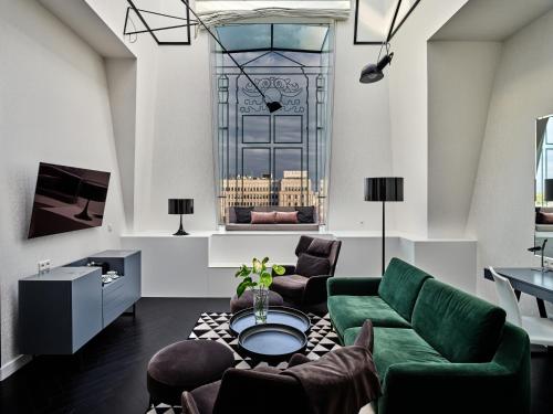 a living room filled with furniture and a large window at Hotel Indigo Warsaw Nowy Świat, an IHG Hotel in Warsaw