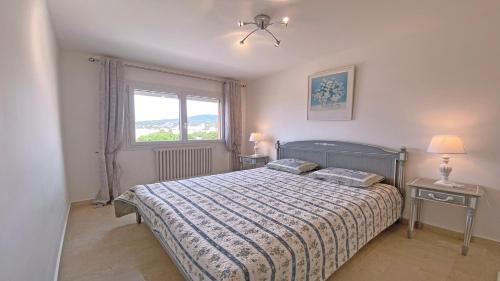 une chambre avec un lit et une fenêtre dans l'établissement Les Saisons, à Sainte-Maxime