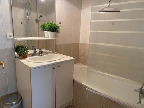 uma casa de banho com um lavatório e uma banheira em Appartement Brides-les-Bains, 3 pièces, 6 personnes - FR-1-512-148 em Brides-les-Bains