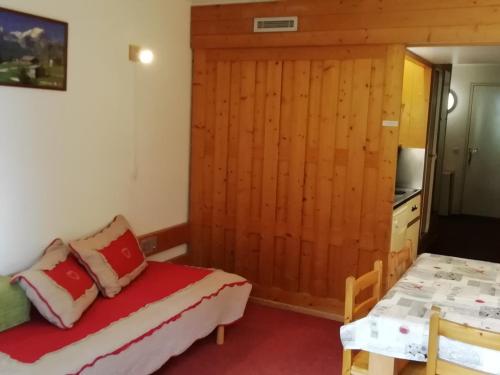 Cette chambre comprend 2 lits et un mur en bois. dans l'établissement Studio confortable 4 pers, skis aux pieds, proche commerces, animaux admis - FR-1-411-326, à Arc 1800
