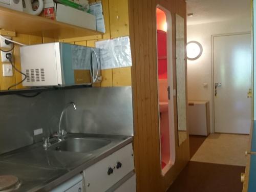 une cuisine avec un évier et un micro-ondes dans l'établissement Studio confortable 4 pers, skis aux pieds, proche commerces, animaux admis - FR-1-411-326, à Arc 1800