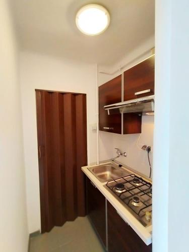 a small kitchen with a sink and a stove at Apartamenty Częstochowa in Częstochowa