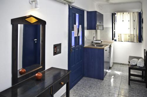 a kitchen with a blue door and a sink at Roula Villa Studios & Apartments in Perissa