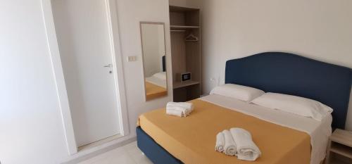 1 dormitorio con 1 cama con 2 toallas en Hotel Mare Blu en Torre dell'Orso