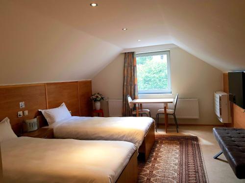 Habitación de hotel con 2 camas y mesa en B&B Le Reclus en Mont-de-l'Enclus