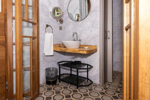 a bathroom with a sink and a mirror at Mükellef Gümüşlük in Bodrum City