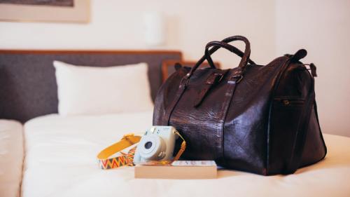 a brown purse sitting on a table next to a bed at AX Sunny Coast Resort & Spa in St Paul's Bay