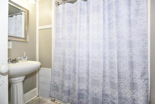 a bathroom with a shower curtain and a sink at ENTIRE HOME*CHERRY ST*FOOD*FUN*DRINKS*SHOP* in Tulsa
