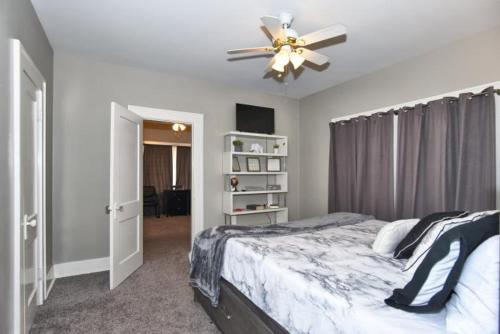 a bedroom with a bed and a ceiling fan at ENTIRE HOME*CHERRY ST*FOOD*FUN*DRINKS*SHOP* in Tulsa