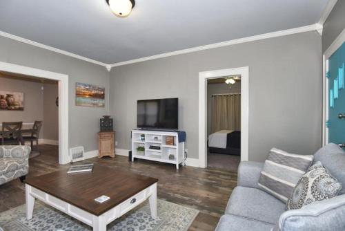 a living room with a couch and a tv at ENTIRE HOME*CHERRY ST*FOOD*FUN*DRINKS*SHOP* in Tulsa