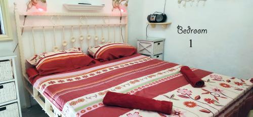 a bedroom with a bed with red and white sheets at Apartment Alena with terrace and garden Center Jelsa in Jelsa