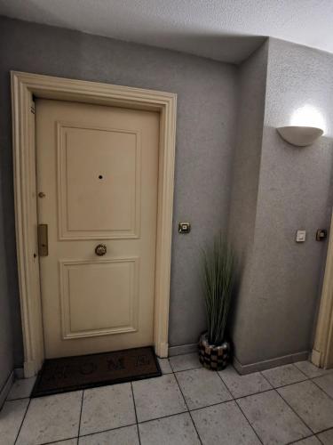 une porte blanche dans une pièce avec une plante en pot dans l'établissement Studio Le Grand Bleu Fshh, à Nice