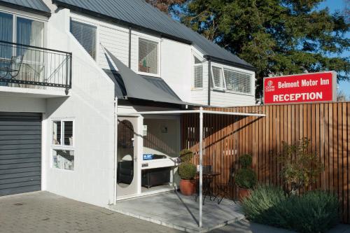 a white house with a sign that readsanimal market reception at Belmont Motor Inn in Christchurch