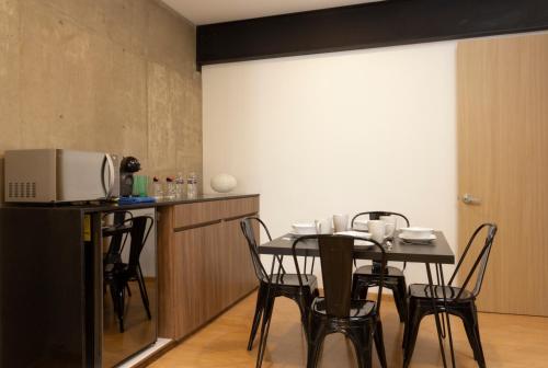 a dining room with a table and chairs and a white screen at El Doce by HomiRent in Laborcillas
