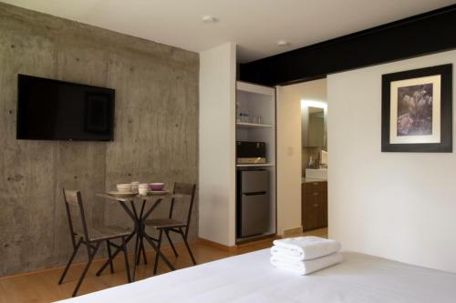 a bedroom with a bed and a table with chairs at El Doce by HomiRent in Laborcillas