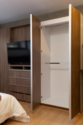 a bedroom with a closet with a flat screen tv at El Doce by HomiRent in Laborcillas