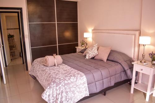 1 dormitorio con 1 cama, 2 mesas y 2 lámparas en Departamento de los Boulevares en Córdoba