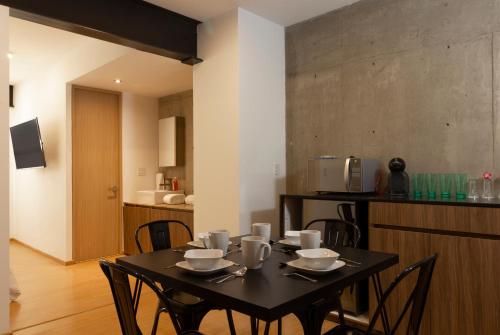 a dining room table with chairs and a kitchen at El Doce by HomiRent in Laborcillas