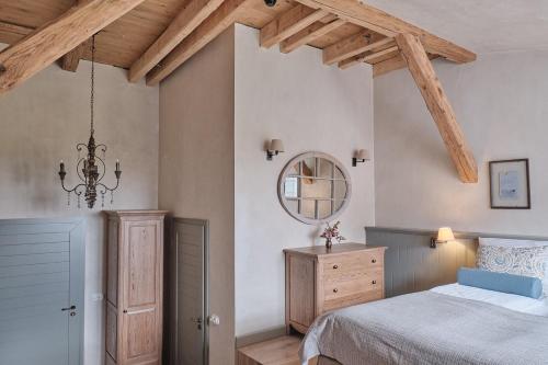 a bedroom with a bed and a mirror and a dresser at Pałac Kamieniec in Polanica-Zdrój