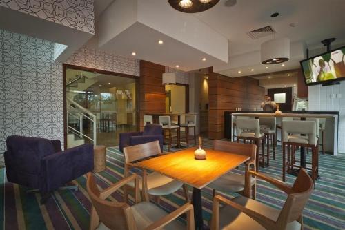 un ristorante con tavolo e sedie e un bar di Lobie Barra da Tijuca Mundo Novo a Rio de Janeiro