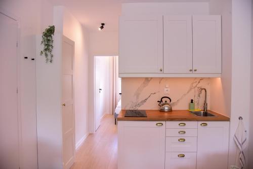 a kitchen with white cabinets and a sink at Apartamenty Turystyczna 25 in Kudowa-Zdrój