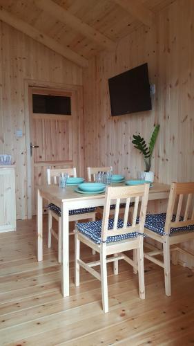 a wooden dining room with a table and chairs at Domy "Pod Brzozami" in Ustka