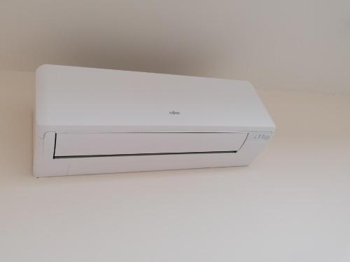 a white air conditioner sitting on top of a wall at Le Repos in Brakel