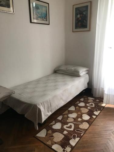 a bed sitting in a room with a rug at Dany Sweethouse in Bergamo