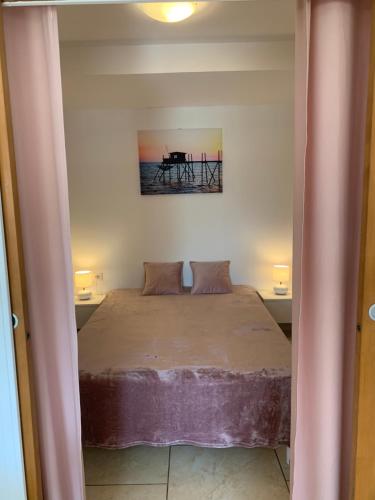 聖艾格夫的住宿－Le Venise 3 Etoiles Frejus，一间卧室配有一张床和一张桌子
