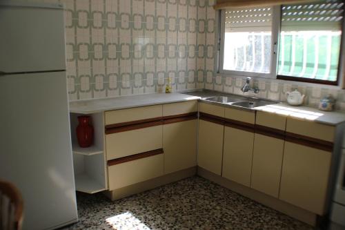una pequeña cocina con fregadero y ventana en Cala Llanetes, en Vinarós