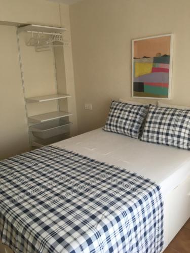 a bedroom with a bed with a checkered blanket at MAGNO CULLERA- Playa in Cullera