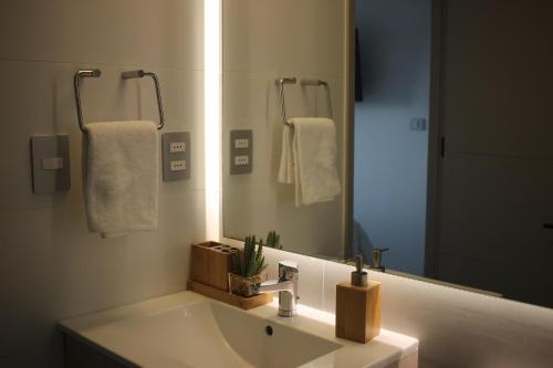 baño con lavabo y espejo grande en Cómodo departamento acceso a dunas de Concón, en Concón