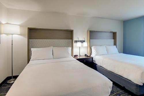 a hotel room with two beds and two lamps at Holiday Inn Mobile Airport by IHG in Mobile