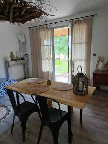 - une table en bois avec 2 chaises et un panier dans l'établissement Chambre d'hôtes indépendante à la campagne, à Saint-Just-le-Martel