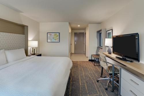 a hotel room with a television and a bed at Holiday Inn Mobile Airport, an IHG Hotel in Mobile