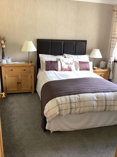 a bedroom with a large bed with two night stands at Mayfield B&B in Fort William