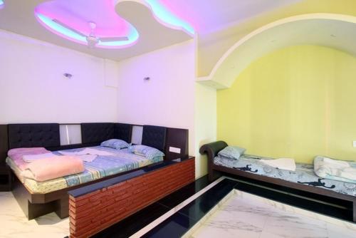 a room with two beds in a room with a ceiling at Rahul Guest House in Varanasi
