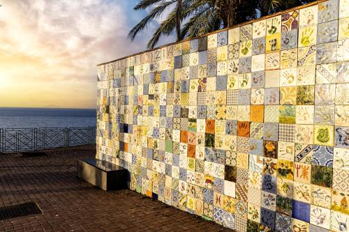 a wall with tiles on it next to the ocean at La dimora dei ricci in Santo Stefano di Camastra