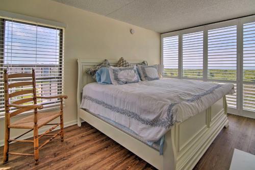 a bedroom with a bed and a chair and windows at Welcoming Brigantine Condo with Ocean Views! in Brigantine