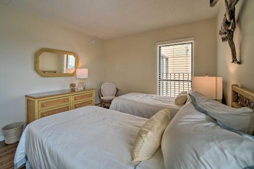 a bedroom with two beds and a mirror and a window at Welcoming Brigantine Condo with Ocean Views! in Brigantine