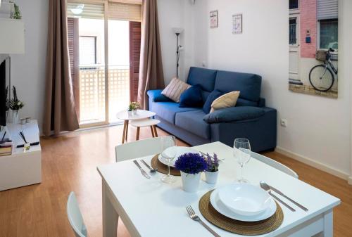 a living room with a table and a blue couch at Apartamento Buen Camino in Benidorm